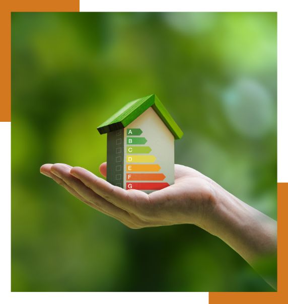 Casa sostenible con etiqueta de eficiencia energética sobre una mano